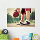Young man on basketball court dribbling with bal Wall Mural