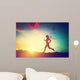Silhouette of woman running at sunset Wall Mural