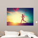 Silhouette of woman running at sunset Wall Mural