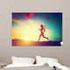 Silhouette of woman running at sunset Wall Mural