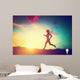 Silhouette of woman running at sunset Wall Mural