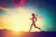 Silhouette of woman running at sunset Wall Mural