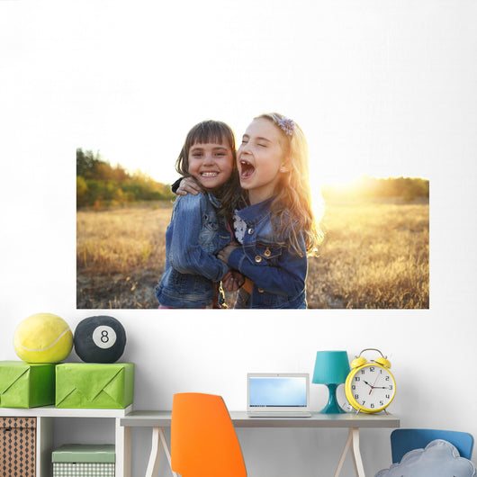 Two cheerful friends snuggling outdoors in the park Wall Mural
