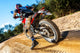 Motocross bike taking off on dirt road. Wall Mural
