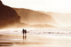 couple walking on beach with fog Wall Mural