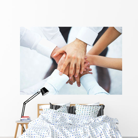 International business team showing unity with their hands toget Wall Mural