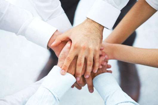 International business team showing unity with their hands toget Wall Mural