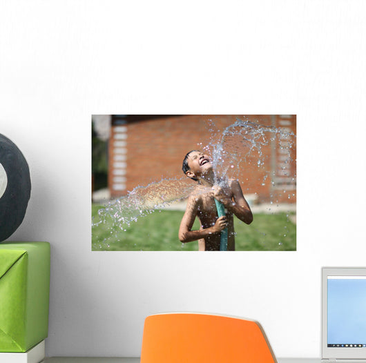 boy with splash water in hot summer day outdoors Wall Mural