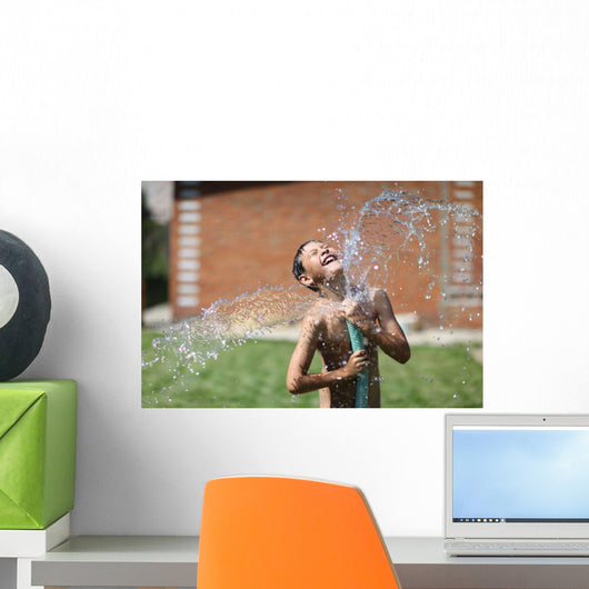 boy with splash water in hot summer day outdoors Wall Mural
