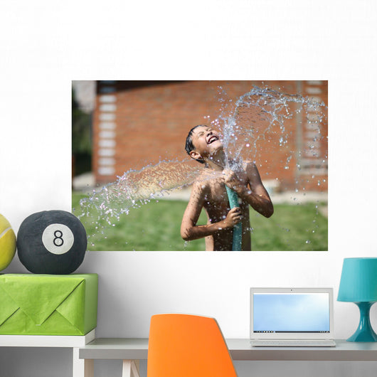 boy with splash water in hot summer day outdoors Wall Mural
