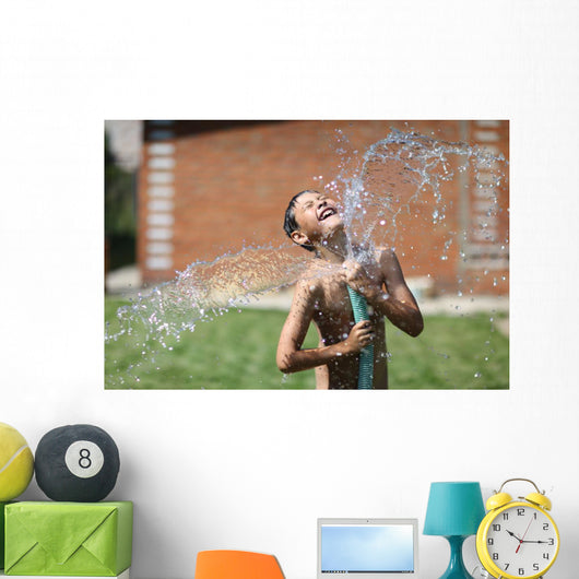 boy with splash water in hot summer day outdoors Wall Mural