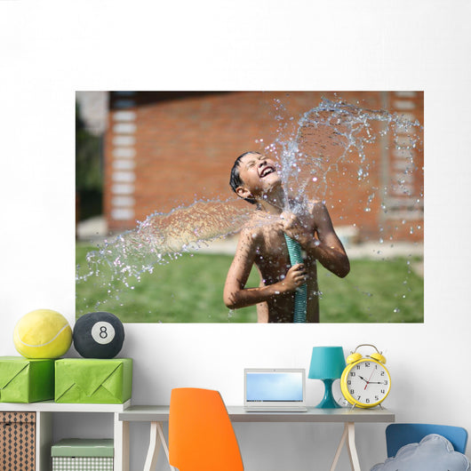 boy with splash water in hot summer day outdoors Wall Mural