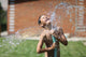 boy with splash water in hot summer day outdoors Wall Mural