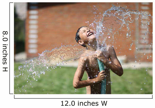 boy with splash water in hot summer day outdoors Wall Mural