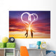 Happy couple in love jump making heart symbol of light Wall Mural