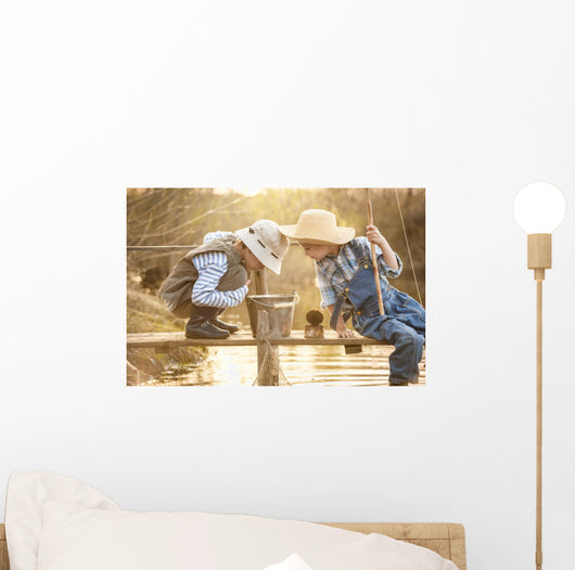 Boy fishes on a bridge on the lake Wall Mural