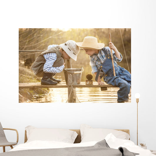 Boy fishes on a bridge on the lake Wall Mural