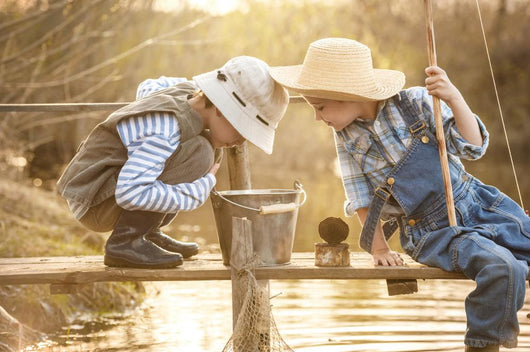 Boy fishes on a bridge on the lake Wall Mural