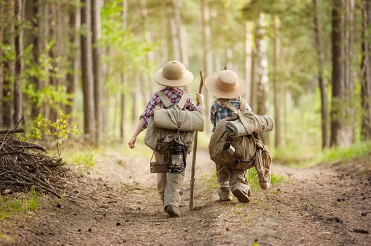 Boys on a forest road with backpacks Wall Mural