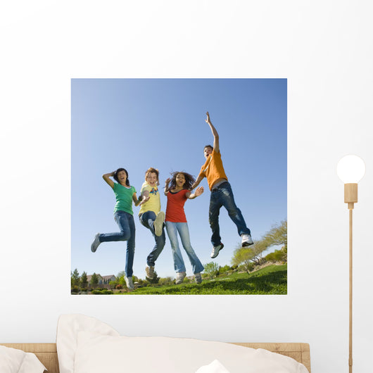 Happy teens jump in air. Wall Mural