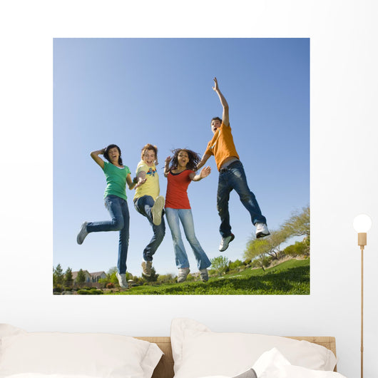 Happy teens jump in air. Wall Mural