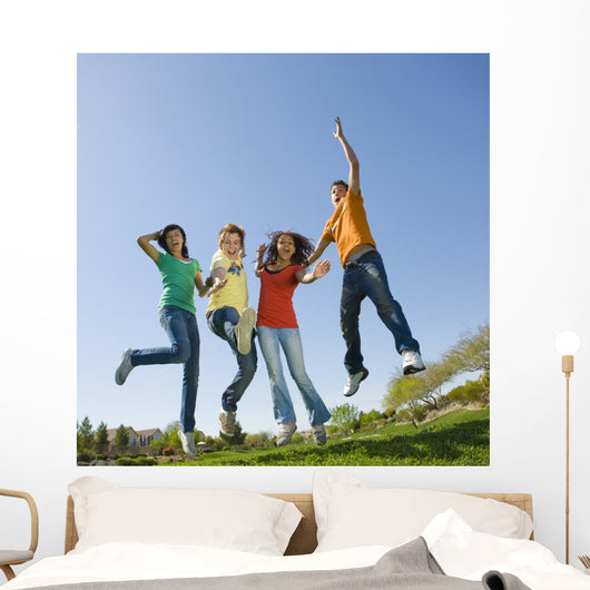 Happy teens jump in air. Wall Mural
