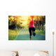 woman runner running at tropical park Wall Mural