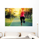 woman runner running at tropical park Wall Mural