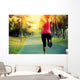 woman runner running at tropical park Wall Mural