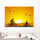 Mountain bike at sunset with child Wall Mural