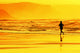 person running on beach at sunset Wall Mural