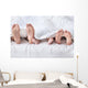 Feet of a family sticking out from the white quilt Wall Mural