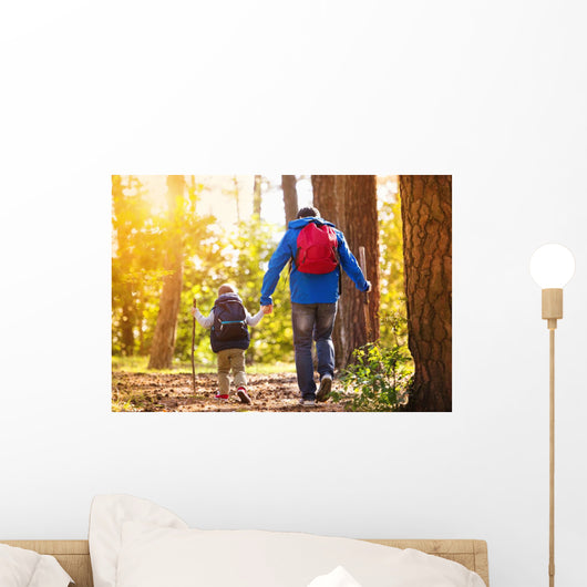 Father and son walking in autumn forest Wall Mural