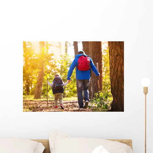 Father and son walking in autumn forest Wall Mural