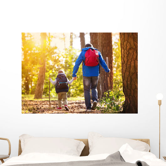 Father and son walking in autumn forest Wall Mural