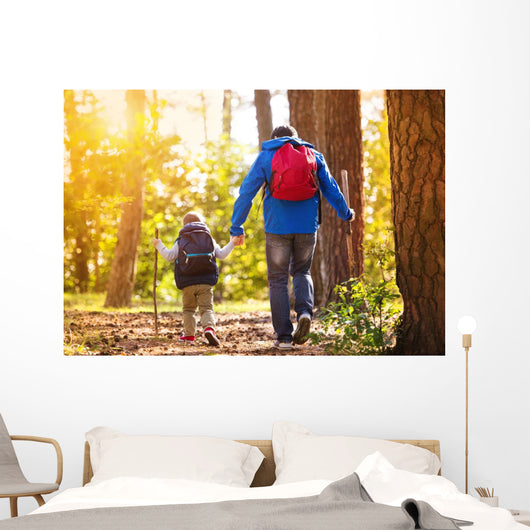 Father and son walking in autumn forest Wall Mural