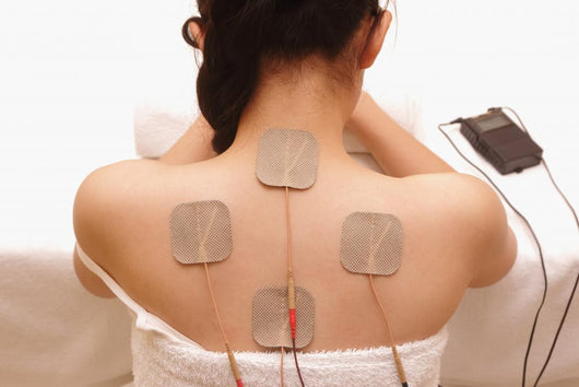 Asian woman is doing massage of electrical -stimulation ( TENs ) Wall Mural