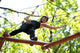 woman climbing in adventure rope park in safety equipment Wall Mural