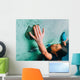 Woman climbing up on wall in gym Wall Mural