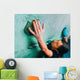 Woman climbing up on wall in gym Wall Mural
