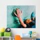 Woman climbing up on wall in gym Wall Mural