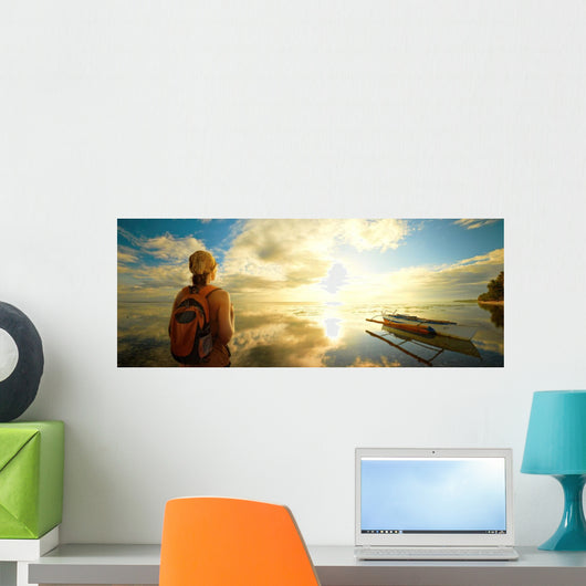 Woman a backpack looking at the sunset. Wall Mural