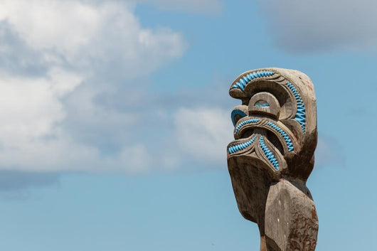 Maori totem against blue sky Wall Mural