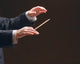 Concert conductor's hands with a baton, isolated on a black Wall Mural