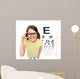smiling little girl in eyeglasses with eye chart Wall Mural
