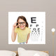 smiling little girl in eyeglasses with eye chart Wall Mural