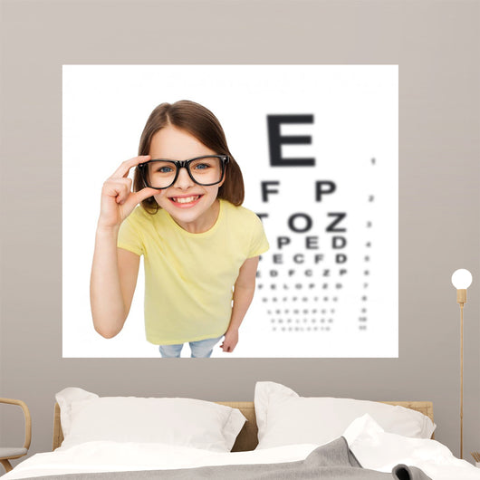 smiling little girl in eyeglasses with eye chart Wall Mural