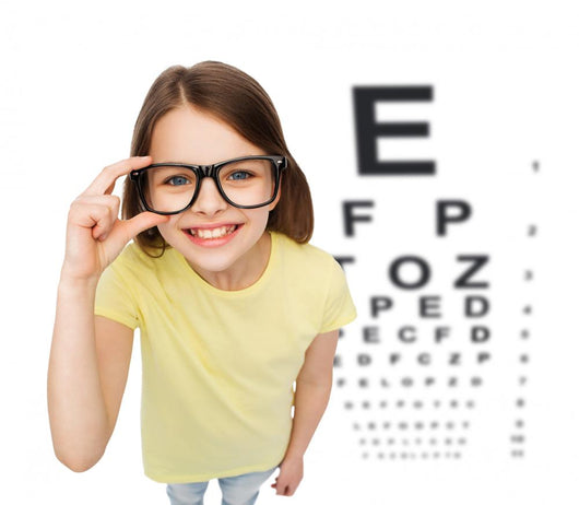 smiling little girl in eyeglasses with eye chart Wall Mural