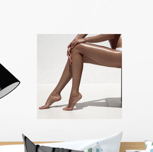 Beautiful woman tan legs. Against white wall. Wall Mural