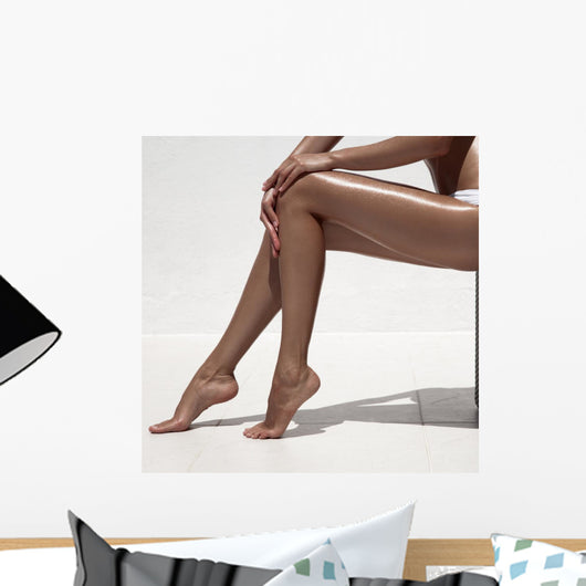 Beautiful woman tan legs. Against white wall. Wall Mural